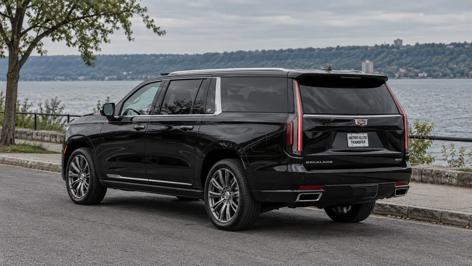 A black Cadillac Escalade ESV with a Metro Elite Transfer plate in a lakeside setting